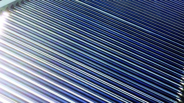 Ein Solarthermie-Kollektorfeld in Senftenberg. Im Hintergrund blauer Himmel mit wenigen kleinen Wolken