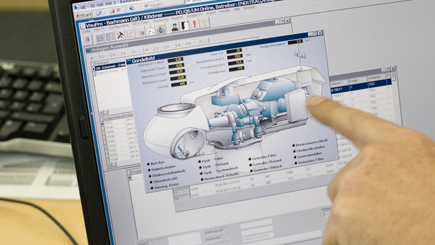 Eine Hand zeigt auf einen Bildschirm, auf dem Energieanlagen zu sehen sind